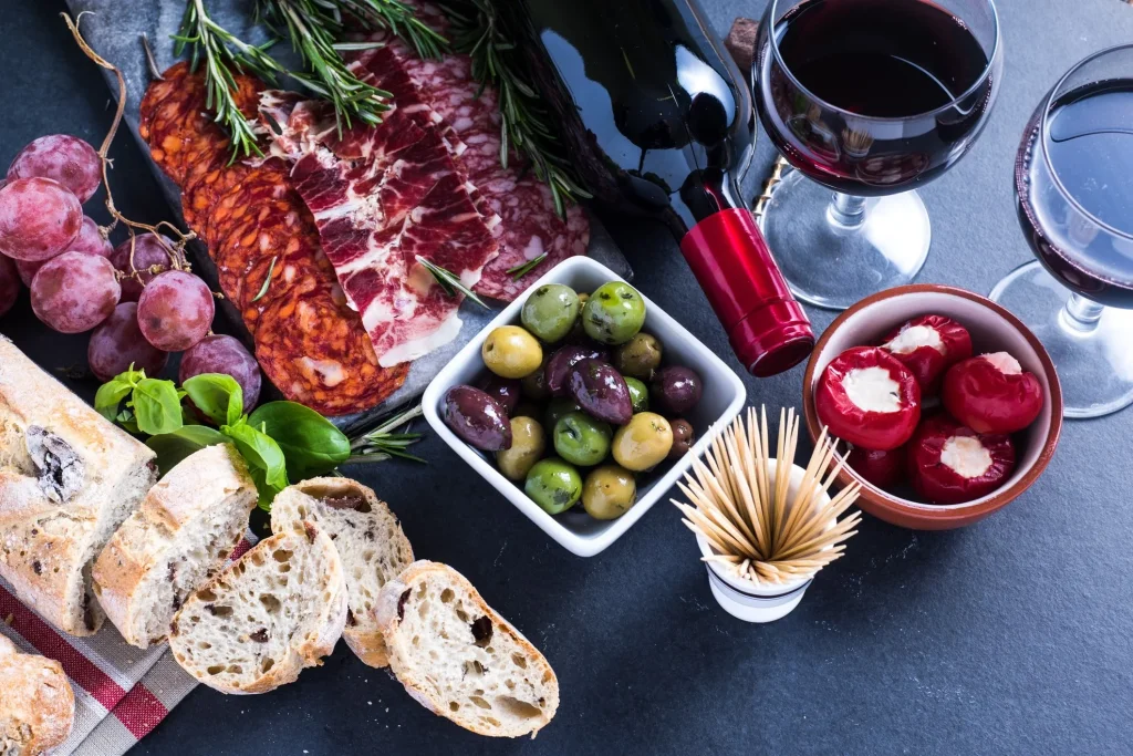 Tapasbuffet met brood, vleeswaren, olijven en gevulde pepers